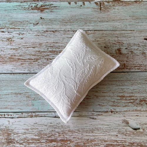 Funda almohada de punto blanco con relieve.